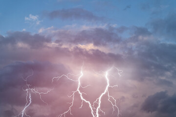 Fototapeta na wymiar Lightning strikes between gloomy stormy clouds.
