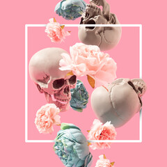 Skulls and flowers dropping on the pastel pink background with white frame. Springtime, Santa Muerte minimal concept.