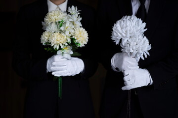 Mourning man and woman with flowers at funeral 