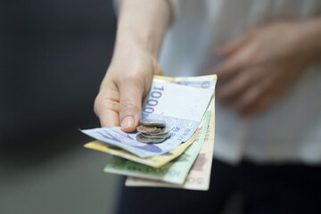 Woman holding cash and coins