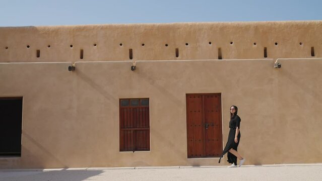 woman tourist visiting the ancient fortress of Al Zubarah at Qatar landmark
