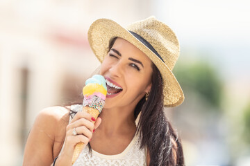 Beautiful happy woman licks ice cream during a hot summer day