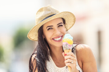 Beautiful happy woman licks ice cream during a hot summer day