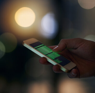 Hacking has never been easier. Shot of an unidentifiable computer hacker using a smartphone to hack into a network.