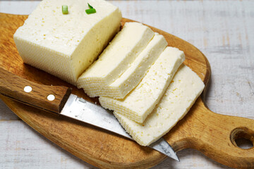 tasty lunch in rural style, healthy food - sliced feta cheese and green leek on a white wooden boards