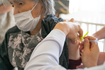 予防接種のワクチンを受ける年配女性