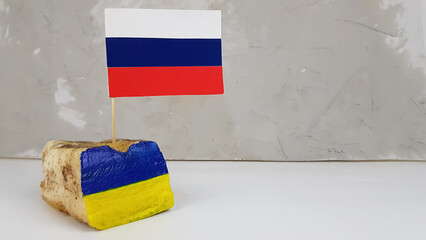 the Russian flag is stuck in the national dish of Ukraine lard. image of the Ukrainian flag on...