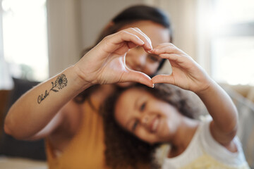 Weve got lots of love to share. Shot of an unrecognizable woman bonding with her daughter at home and making a heart-shaped gesture. - obrazy, fototapety, plakaty