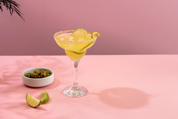 Margarita cocktail . Concept of classic drinks. Refreshing colorful summer drinks on pink background with shadow palm leaf. Bar drinks menu.