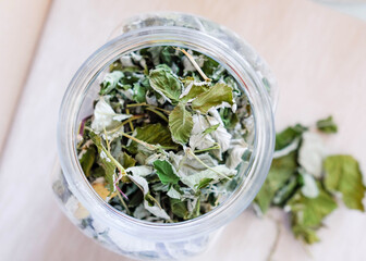 Dried raspberry leaves in a glass jar, top view