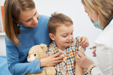 Smiling child receiving vaccine injection in pediatric clinic