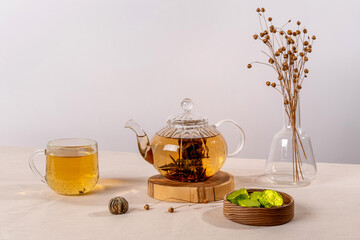 Green tea oolong in glass teapot on table. Hot tea is in the glass cup.