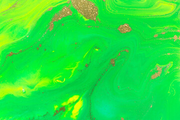 Gold spots on flow green vivid paints background. Abstract print