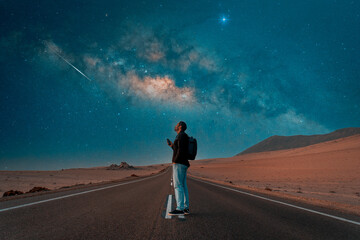 person standing on the road under milky way at night.