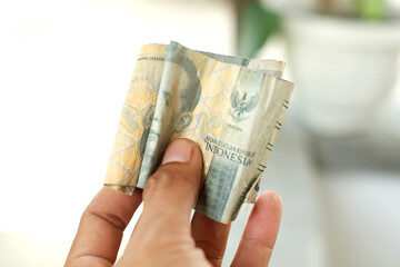 Hand holding rupiah banknote