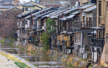 Restaurants in old wooden buildings line Kamo River in Kyoto