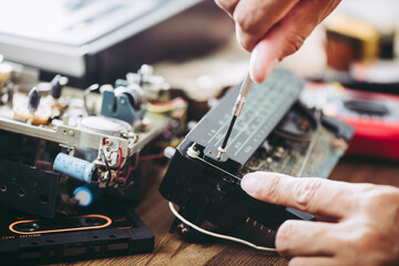 Fototapeta na wymiar Fixing vintage radio cassette recorder