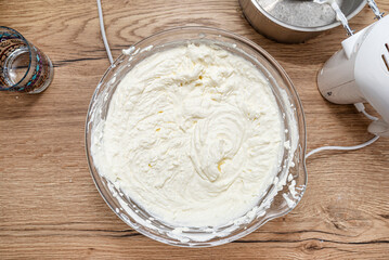 Ready mixed cottage cheese with whipped cream for cheesecake in glass bowl, top view.