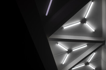 Light design. Fluorescent lamps on ceiling. Triangles of lamps. Interior details.