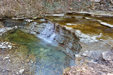 The waterfall on the trail in the woods.