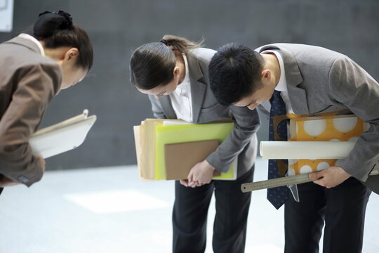 Business people taking bow in corridor