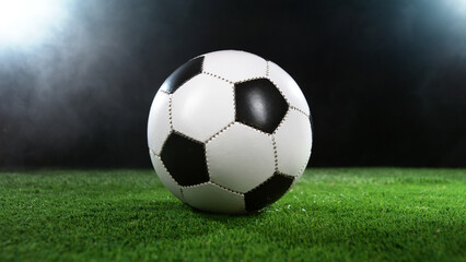 Fototapeta na wymiar Soccer ball on grass with dark background and lights
