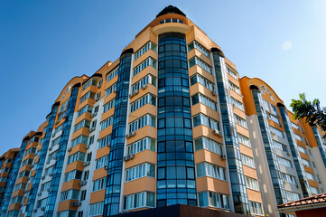 Exterior of a modern multi-story apartment building. Facade, windows and balconies.