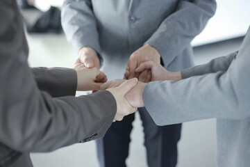 Business people holding hands in circle