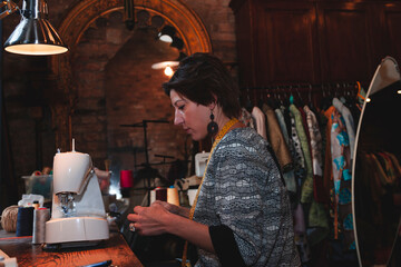 young seamstress is working with the sewing machine