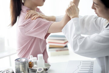 Doctor checking patient's shoulder pain