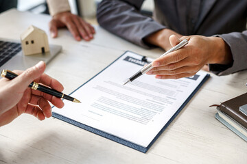 Real-estate agent sign for home contract property for sale in the office with buyer.