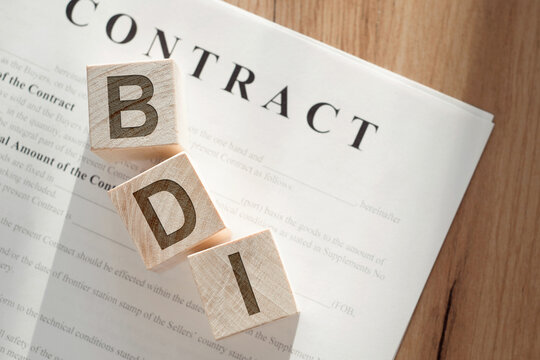 Wooden cubes with the word BDI - brand development index on a paper contract.