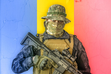 Angry romanian soldier armed with a rifle with romania flag as background behind
