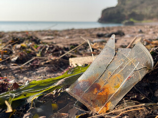 Broken plastic cup pollution on beach in Devon