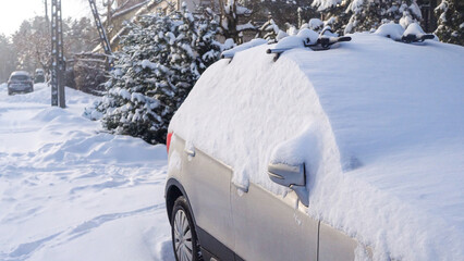 View of a car heavily covered in snow standing in front of a house in the suburbs