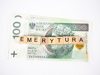 Word retirement written in polish with wooden blocks with money in the background, 