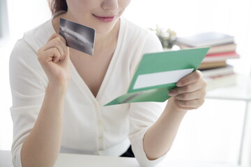 Young woman holding credit card with bank book