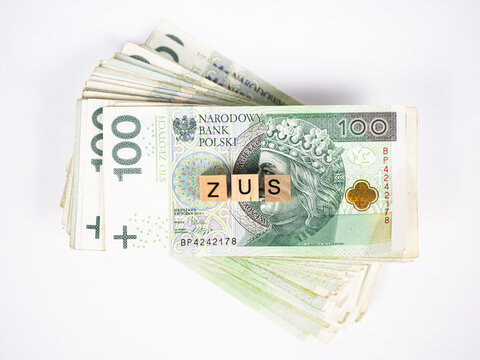 Shortcut of polish social security office written in polish with wooden blocks standing on money, "zus" means Social Security