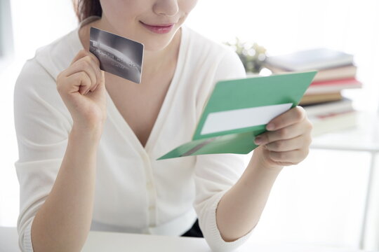 Young woman holding credit card with bank book