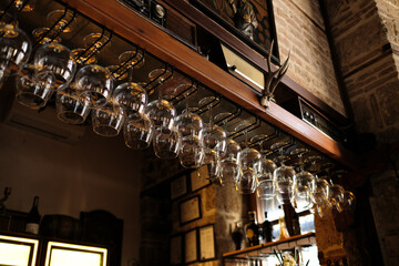 Bar glasses, Empty bar glasses waiting for wine on the bar rack, Bar section in vintage tone, Hanging glasses