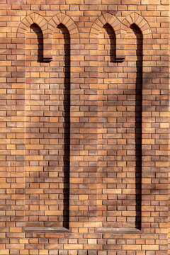 red brickstone wall with dummy windows in arabic style like a mosque