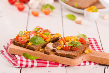 Rye bread withsweet corn, basil and tomato.