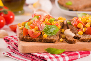 Obraz premium Rye bread withsweet corn, basil and tomato.