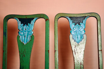 A pair of old, damaged, wooden chairs