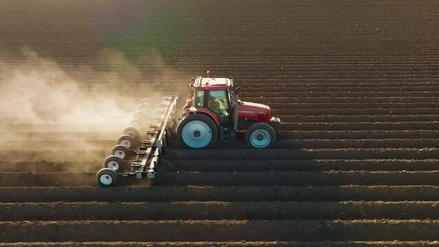 Agricultural tractor plowing a field in rural countryside