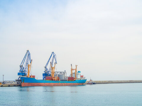 Dry cargo ship in port. Vessel loading. Harbor cranes loading Grain. Food shortage 2022 