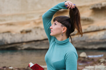 Happy woman holding her hair up with her hand and looking upward