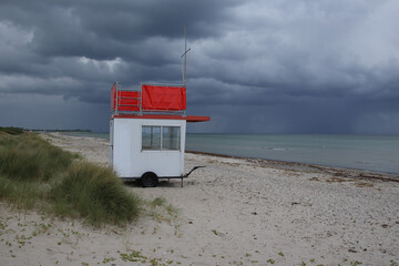 The lookout car of the water rescue service stands alone on the Baltic Sea beach, over which...