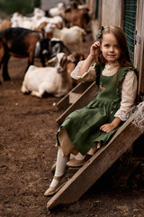 a portrait of cute child in beautiful green dresses walking on a farm