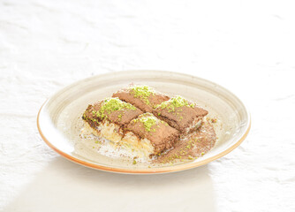 cold baklava. Turkish delight desserts. baklava dessert in a light plate with a glass of tea on a light background